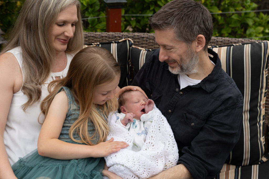 family of 4 on their patio with new baby