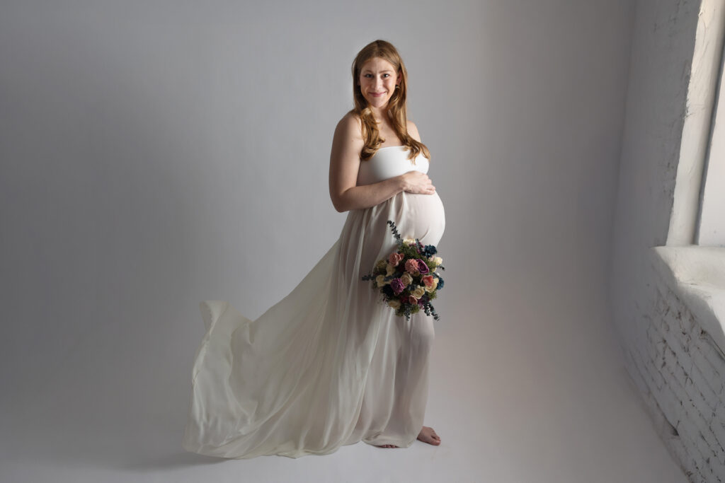beautiful mother to be standing in front of a window
