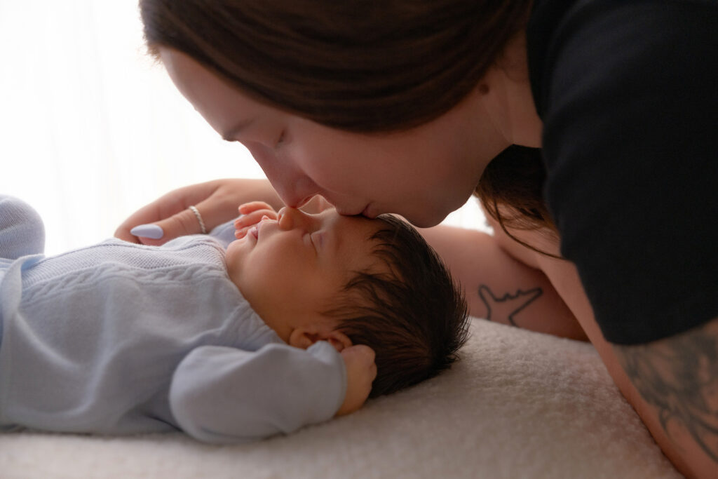 backlit photo of a mom kissing her baby boy; cleveland ohio newborn and family photographer