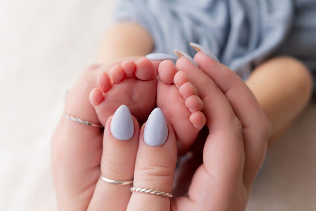 detail image of mom holding her baby's newborn feet in medina county ohio; newborn and family