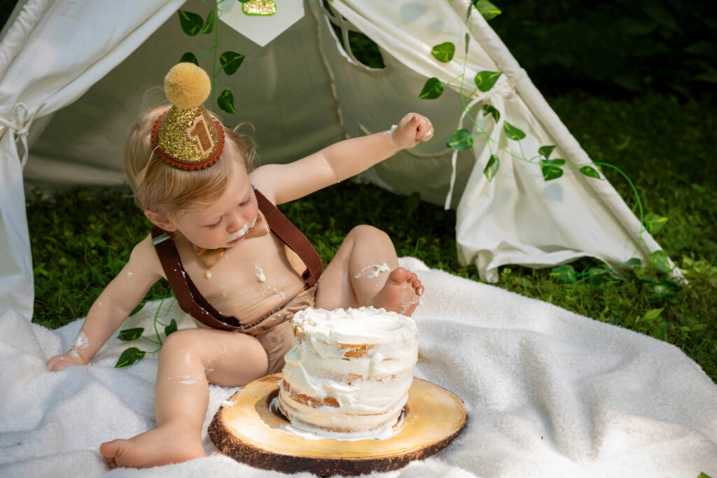 baby boy smashing his birthday cake with his foot