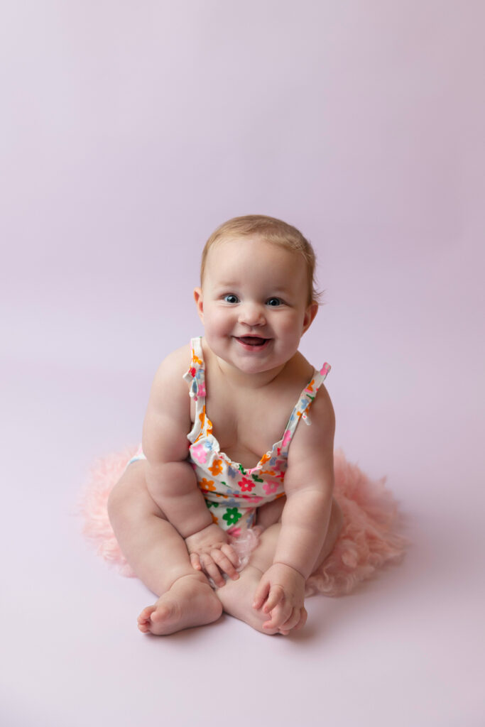 smiling baby girl reaching for her toes
