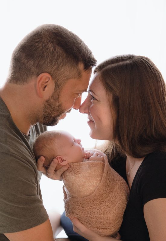 Joyful parents holding their new baby